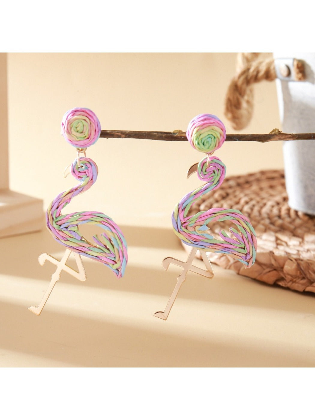 Flamingo earrings placed on a textured surface with natural lighting