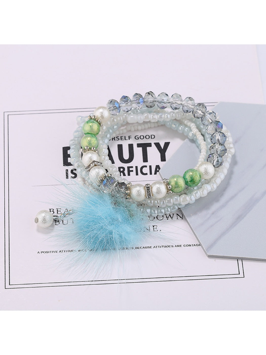 Detailed shot of colorful beads and pink pompom pendant on Lovra bracelet
