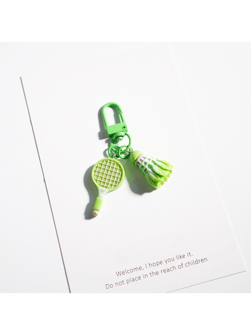 Badminton racket keychain with metal keyring attached, isolated on white