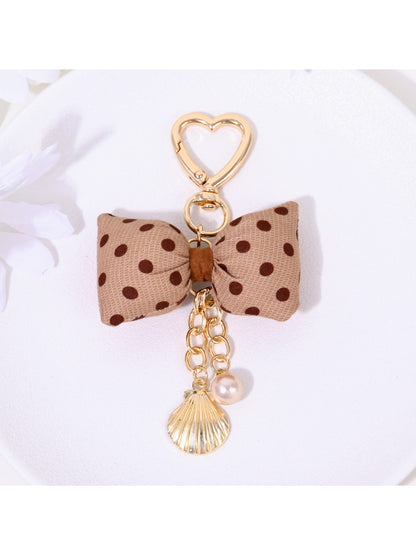 Side view of Keypus polka dot bow keychain highlighting its thickness and shape