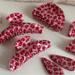 Close-up of Beau pink leopard print acetate hair clip on white background