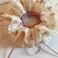 Gifty scrunchie worn on wrist highlighting bow design