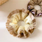 Side view of yellow ruffle scrunchie showing gathered fabric details