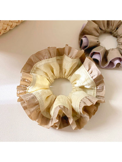 Side view of yellow ruffle scrunchie showing gathered fabric details