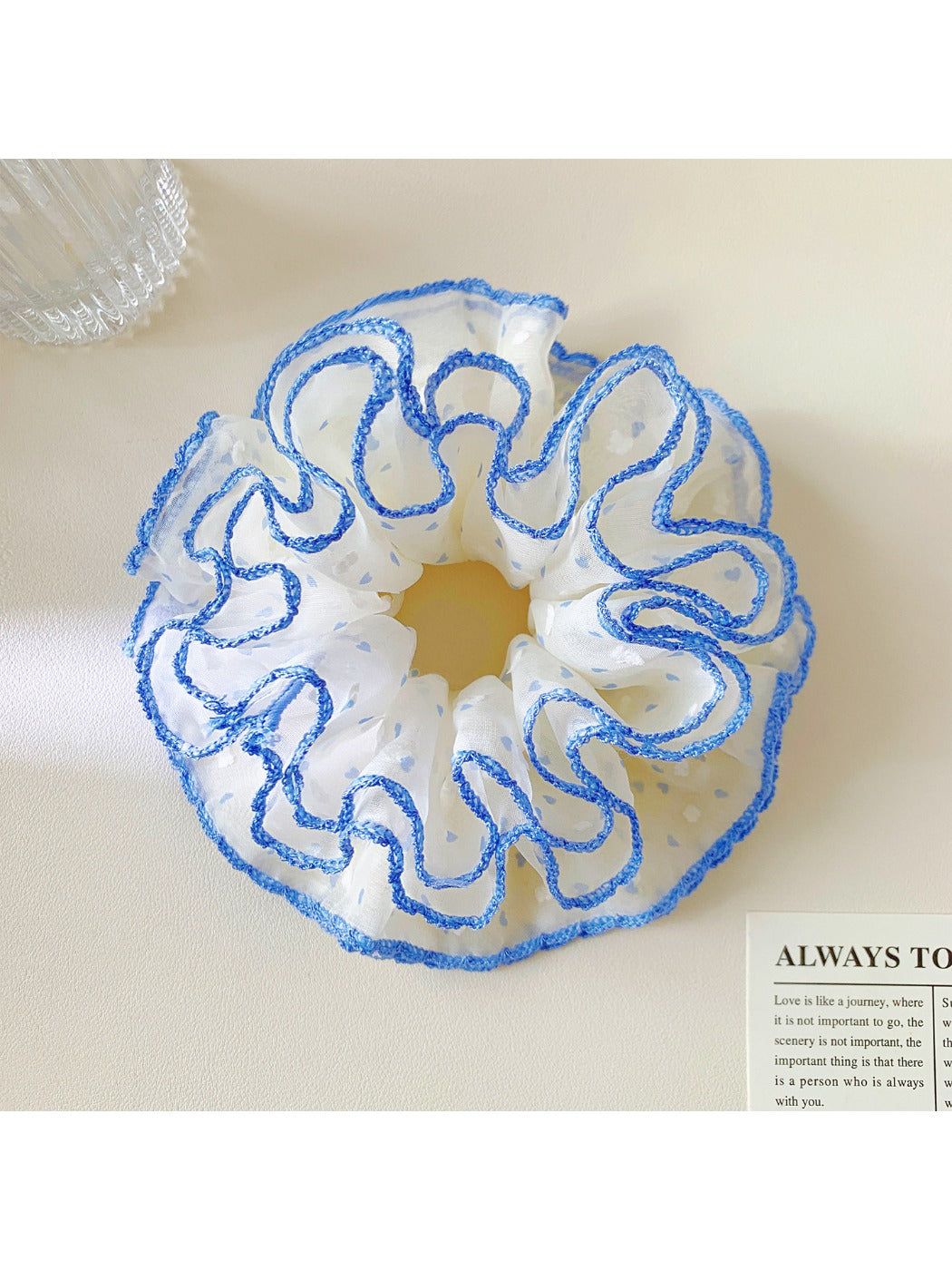 Misty blue scrunchie with white polka dots on a white background