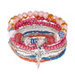 Lovra trendy stackable beaded bracelets displayed on a fabric surface with soft lighting