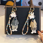 Giraffe charm keychain attached to a set of keys on a wooden surface