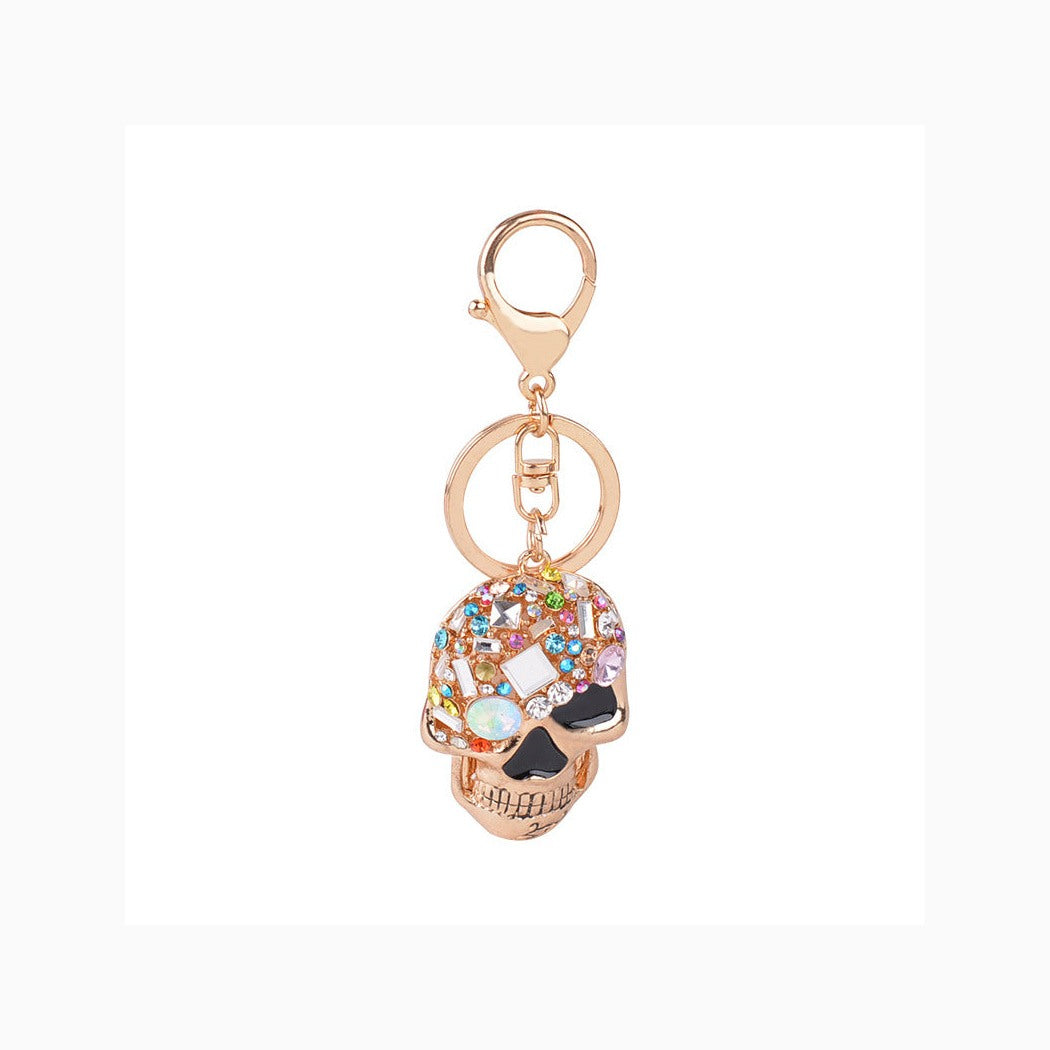 Gold-tone multicolor faceted skull keychain on white background