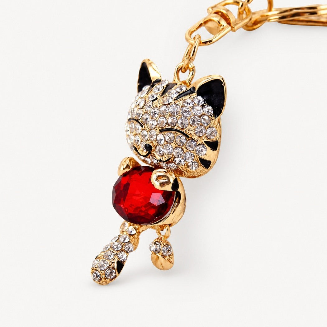 Red faceted cat keychain on neutral background