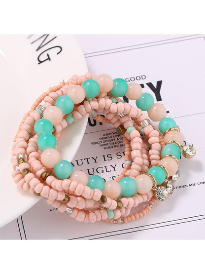 Lovra bracelet worn on wrist featuring rhinestone pendant and vibrant beads
