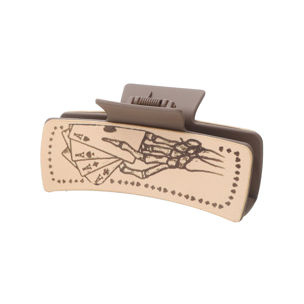 Playing cards and hand hair claw on white background