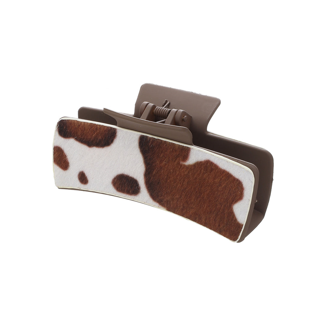 Brown cow print hair claw on white background