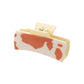 Orange cow print hair claw on white background