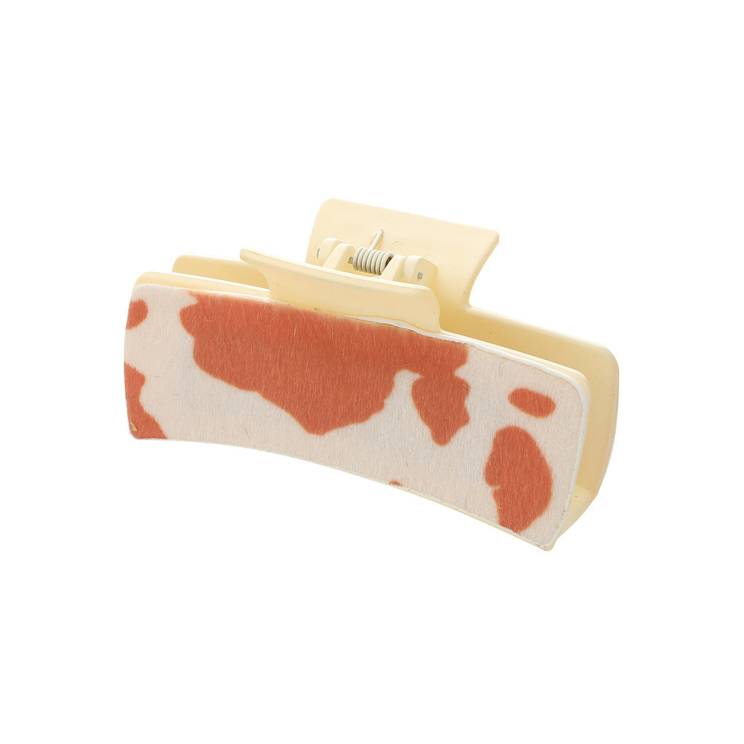 Orange cow print hair claw on white background