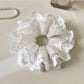 Close-up of Gifty minimalist cutout ruffled scrunchie in soft beige fabric
