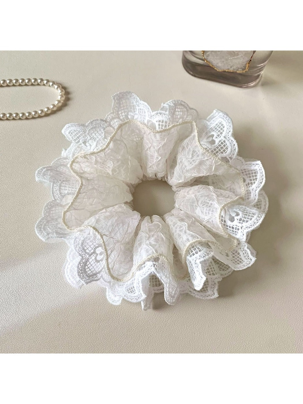 Close-up of Gifty minimalist cutout ruffled scrunchie in soft beige fabric