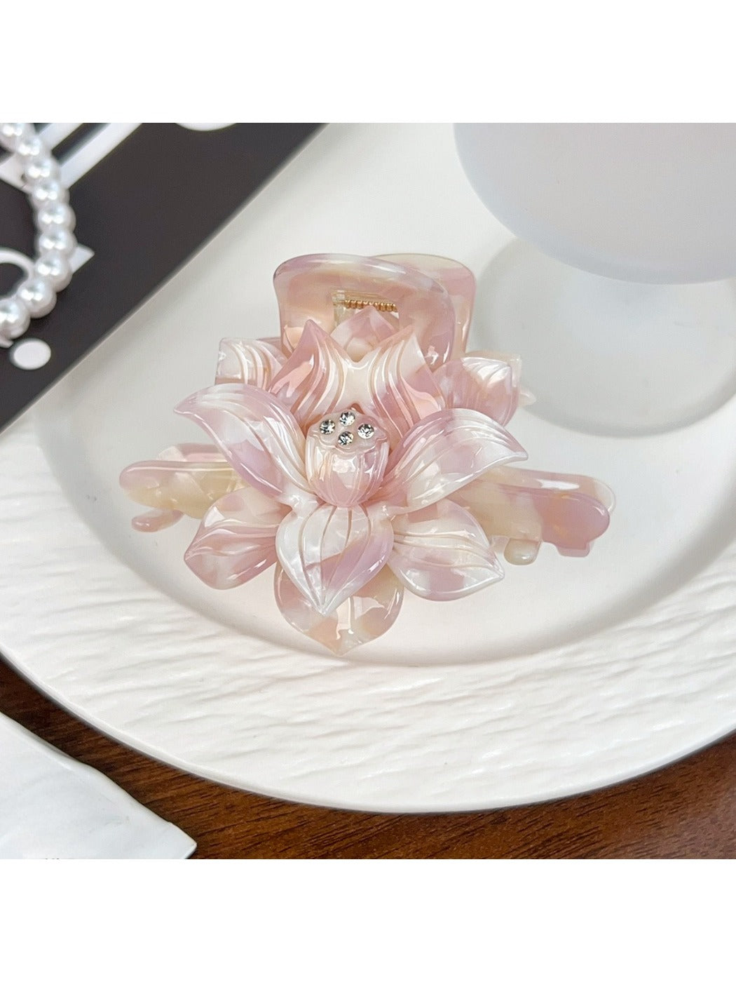 Beau lotus hair claw clip held in hand showing size and shape