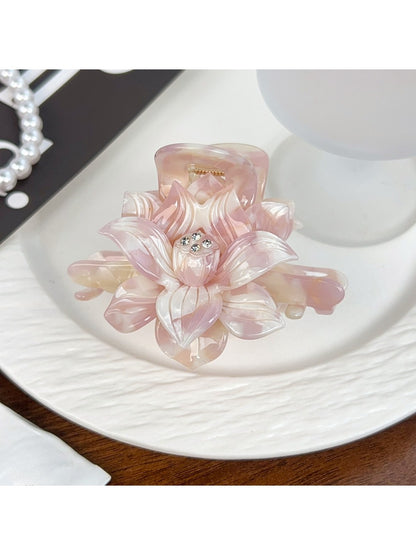 Beau lotus hair claw clip held in hand showing size and shape
