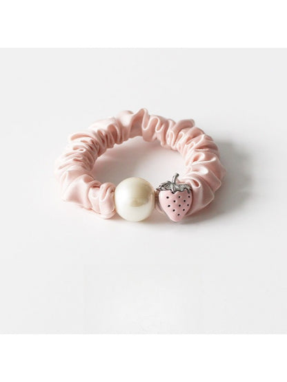 Strawberry hair tie packaged in a clear plastic bag with branding label