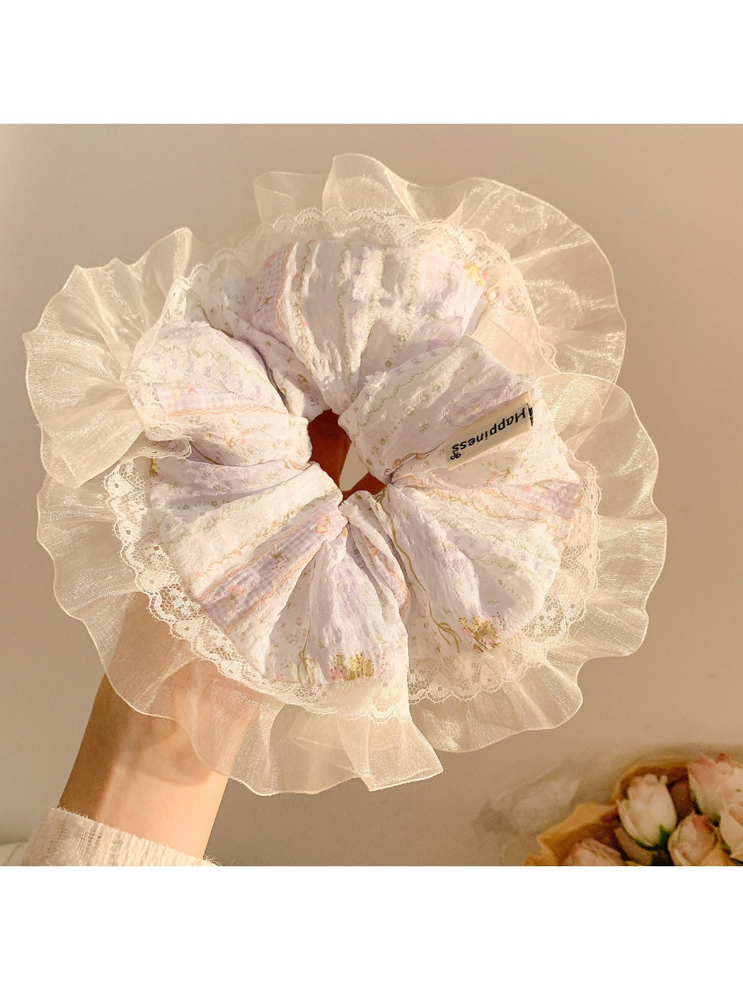 Gifty scrunchie worn on a wrist showcasing floral design and lace edging