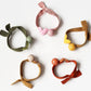 Set of colorful hair ties with small heart decorations on a white background