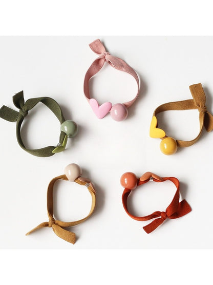 Set of colorful hair ties with small heart decorations on a white background