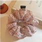 Pink floral tulle scrunchie wrapped around a ponytail