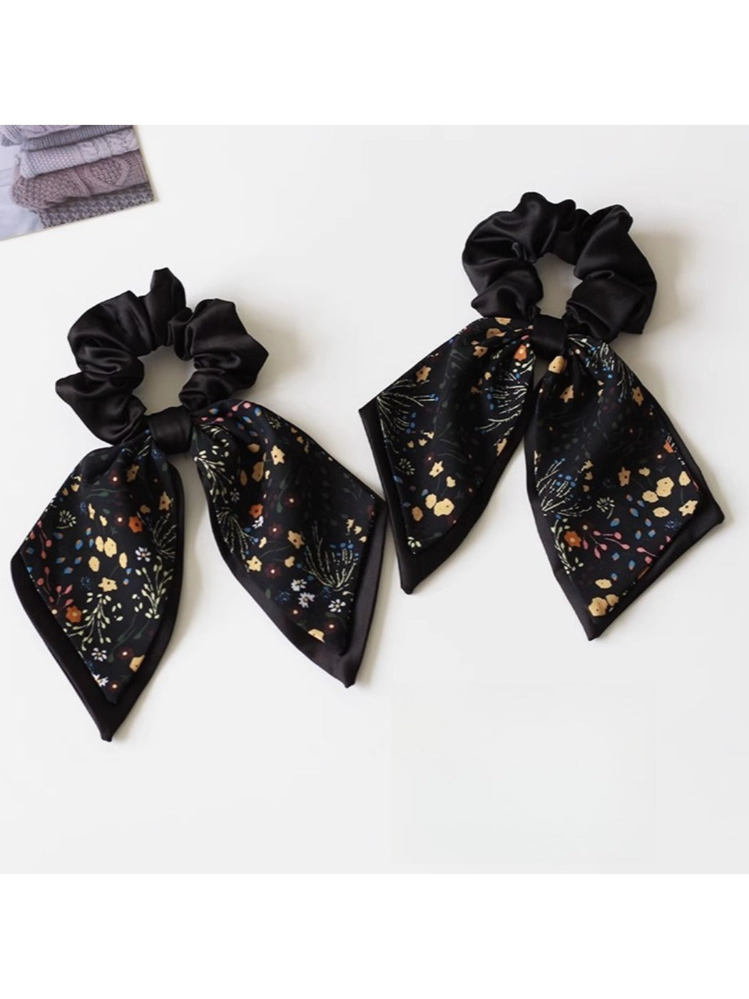 Close-up of Gifty printed bow hair tie with floral pattern on a white background