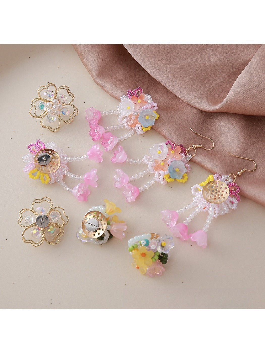 Pair of small flower-shaped earrings with intricate beadwork on a white background