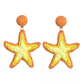 Earedge Starfish Raffia Woven Stud Earrings resting on a wooden surface