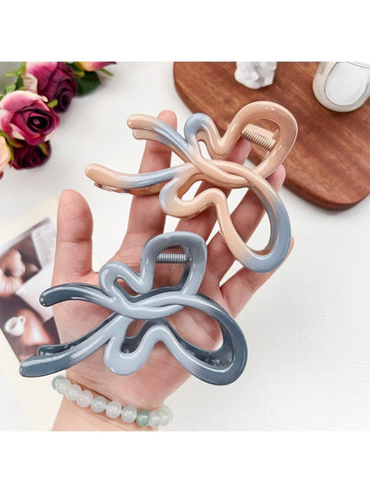 Beau heart shaped bow claw clip held in hand displaying size and ombre color effect