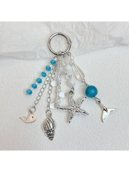 Ocean themed pendant keychain attached to a set of keys with a blurred background