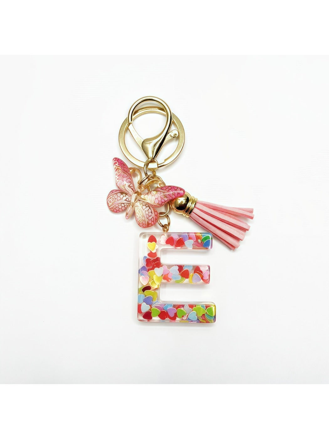 Butterfly and letter keychain displayed with other accessories on a table