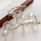 Beau minimalist wave hair claw clip resting on a marble surface