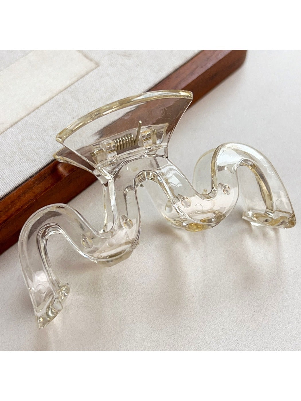 Beau minimalist wave hair claw clip resting on a marble surface