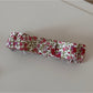 Beau pink floral hair clip held in hand showing size and details