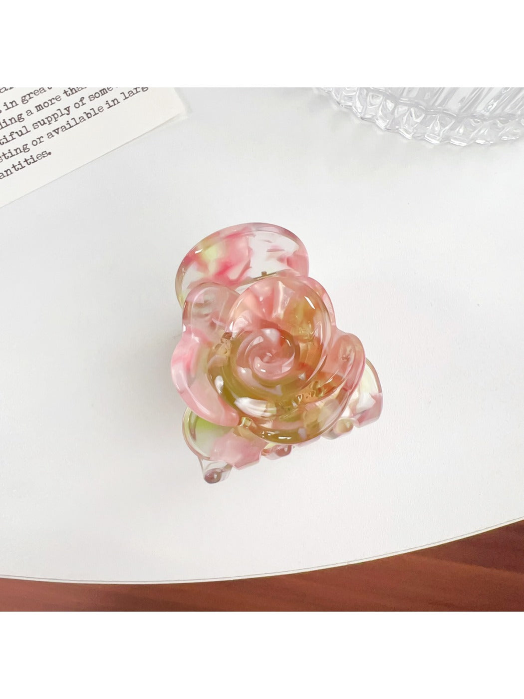 Beau Sweet Rose hair claw clip with pink rose decoration held against a neutral background