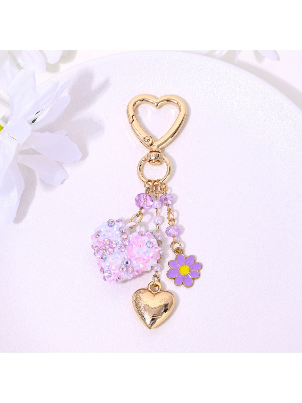 Heart and flower shaped metal keychain with gold finish on white background