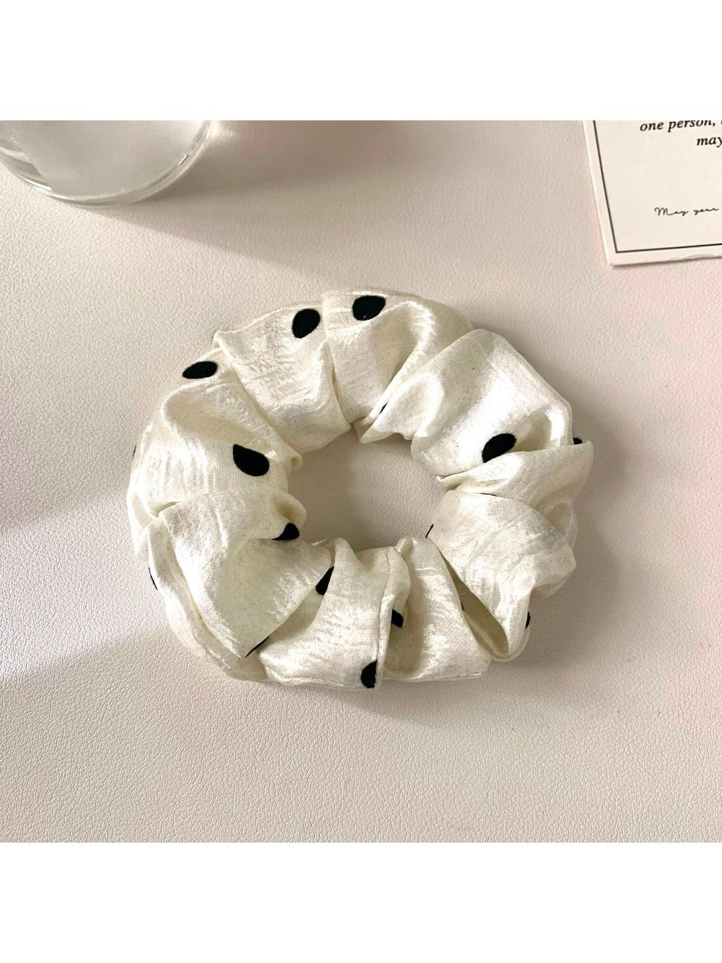Gifty satin scrunchie styled on a wrist as a bracelet with polka dot pattern