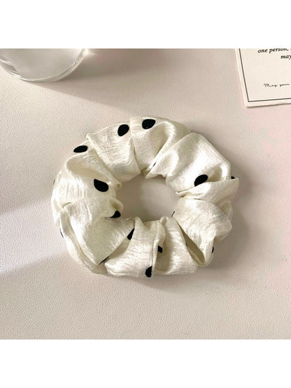 Gifty satin scrunchie styled on a wrist as a bracelet with polka dot pattern