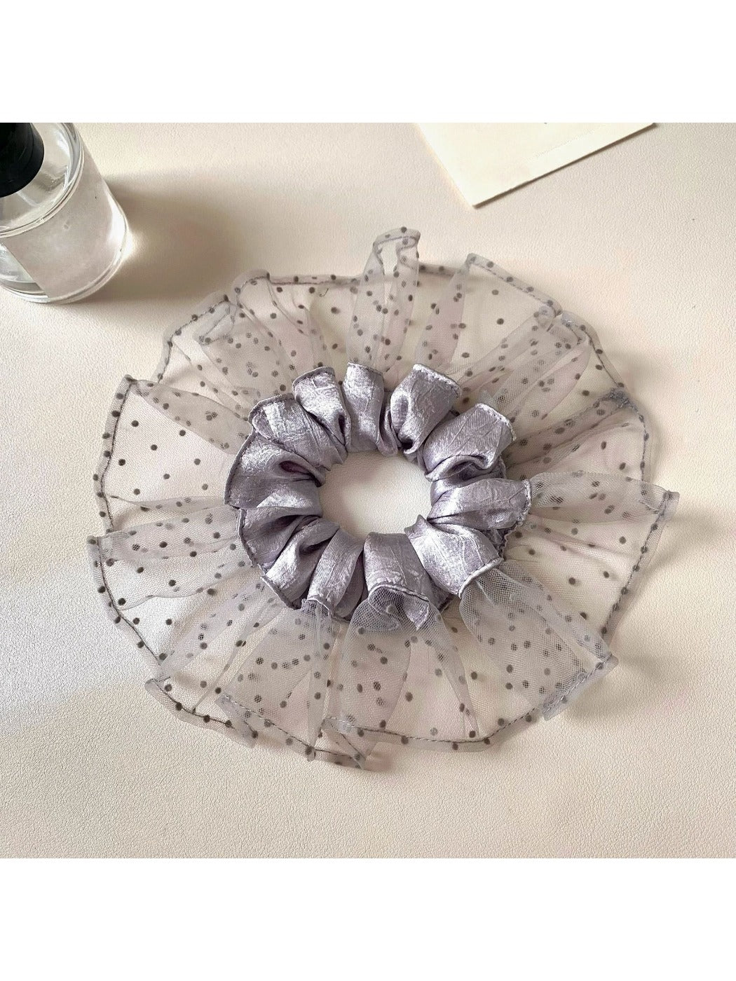 Gray mesh polka dot scrunchie displayed flat showing texture and pattern