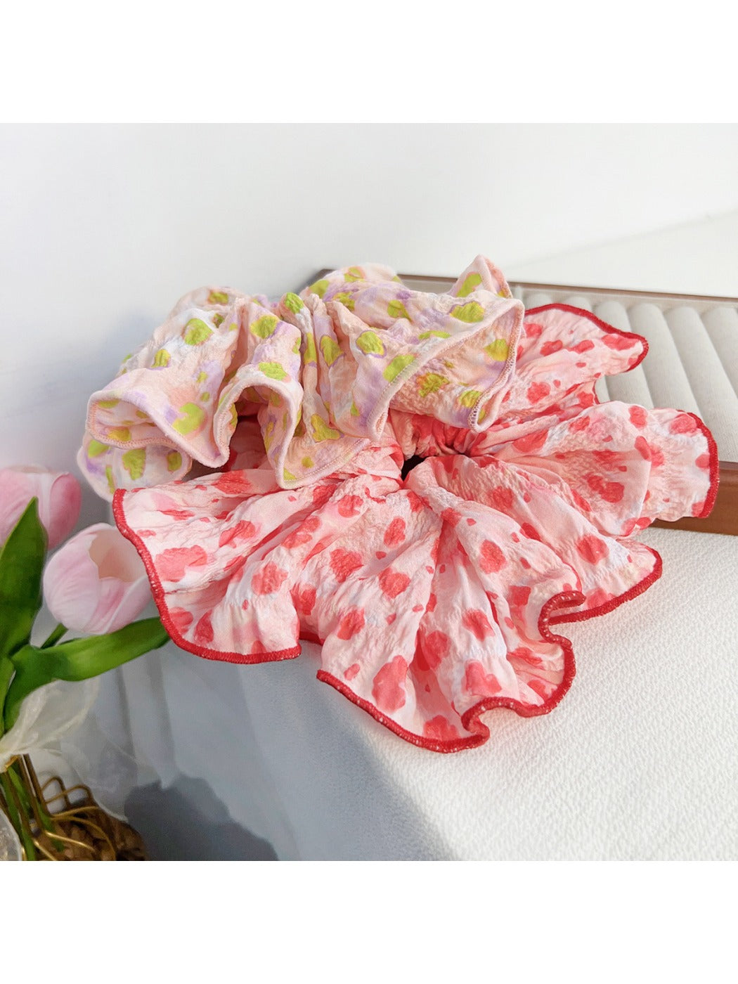 Top view of a black scrunchie with white polka dots laid flat