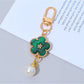 Colorful flower charm keychain hanging from a bag zipper pull