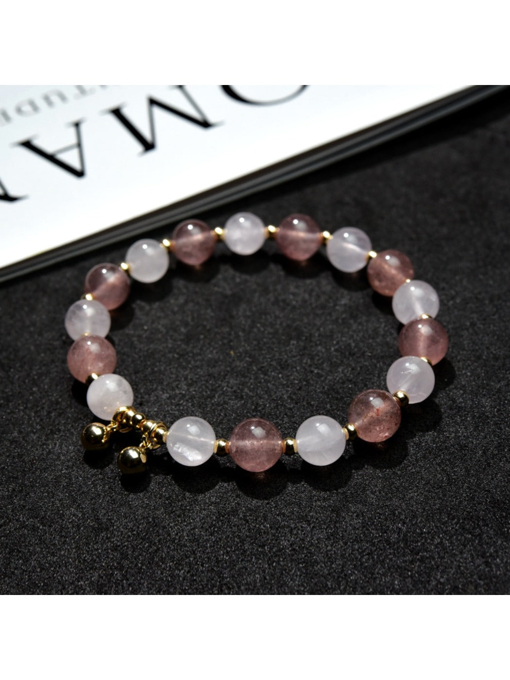 Lovra bracelet with heart pendant displayed on a wooden surface