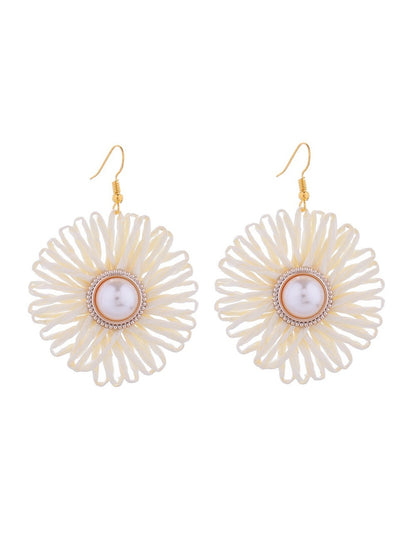 Side view of Earedge raffia woven flower-shaped earring showing texture and weave