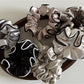 Close-up of Gifty ruffled fabric satin scrunchie in soft pink color