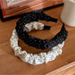 Side view of Gifty minimalist headband with black polka dots on white fabric