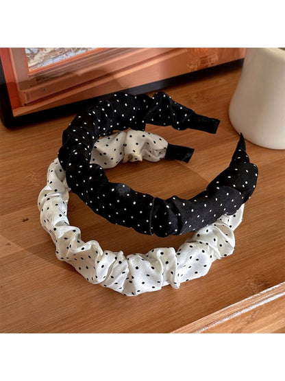 Side view of Gifty minimalist headband with black polka dots on white fabric
