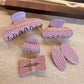 Close-up of Beau pink polka dot claw clip with white dots on a light pink background