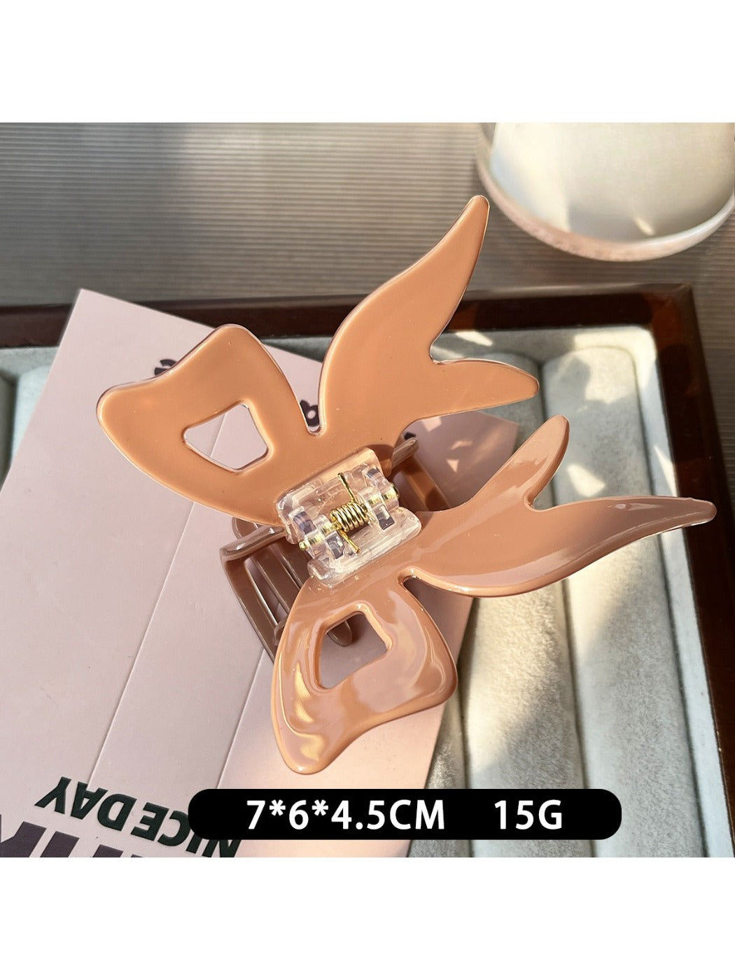 Beau acrylic bow claw clip open showing metal spring mechanism
